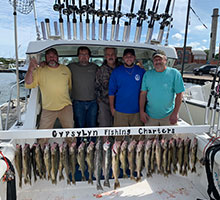 Five happy guys and a board of fish